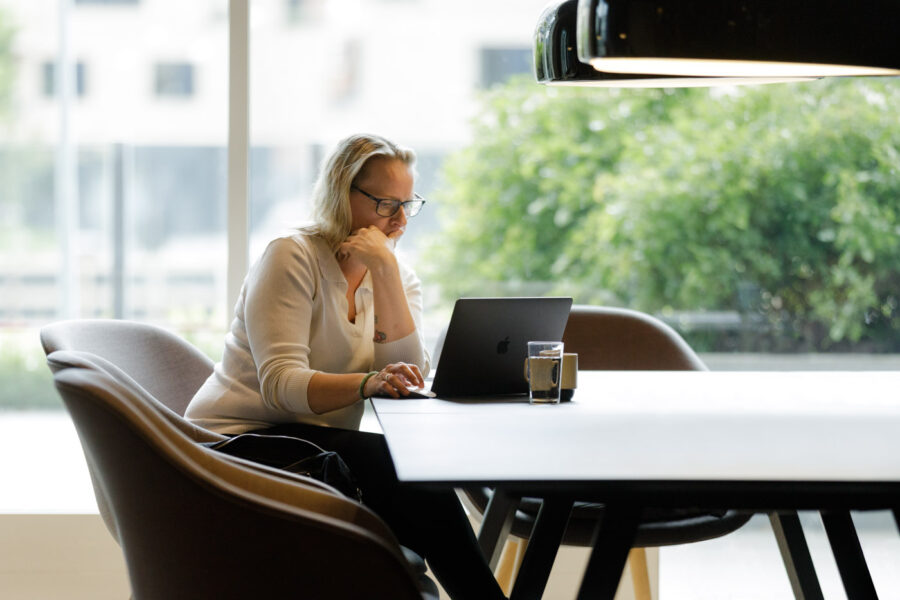 Versemann-Photographic-personlig-branding-kkvinde-ved-bord-med-mac-i-modlys